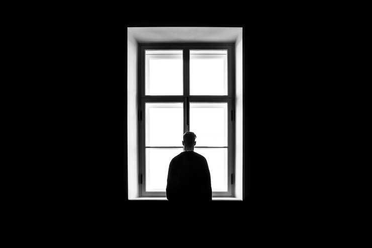 homme seul face à une fenêtre